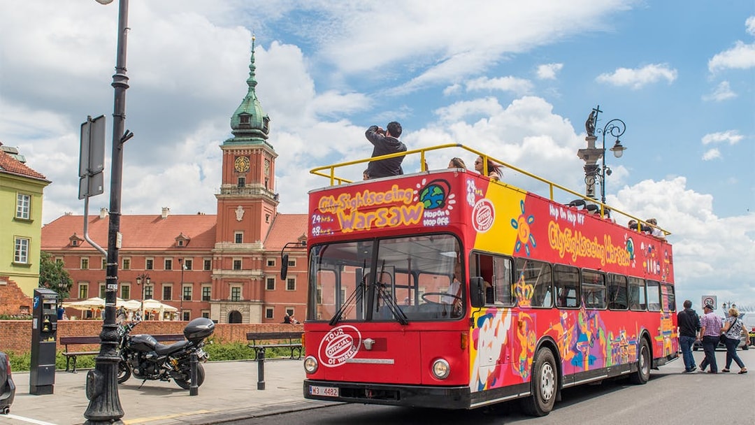 Warsaw hop-on hop-off bus near Royal Castle on a sunny day.