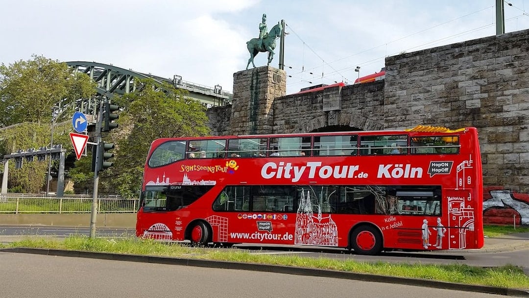Hop on Hop off City Tour bus in front of Hohenzollern Bridge, Cologne.