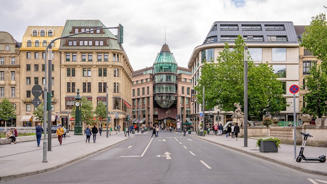 Konigsallee street view in Dusseldorf with historic buildings and pedestrians.