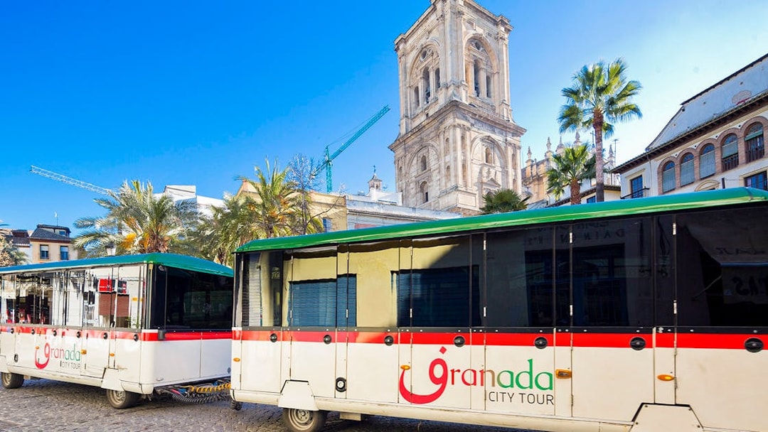 Granada city tour buses in front of historic cathedral.