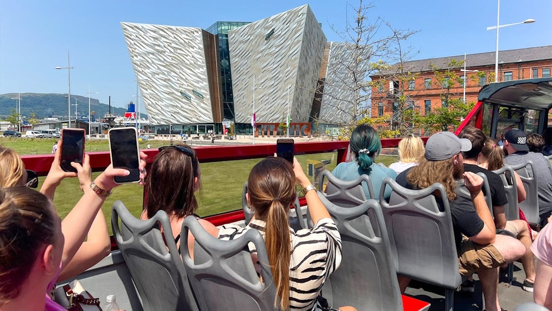 Visitors on a hop-on hop-off bus tour view the Titanic Museum in Belfast.