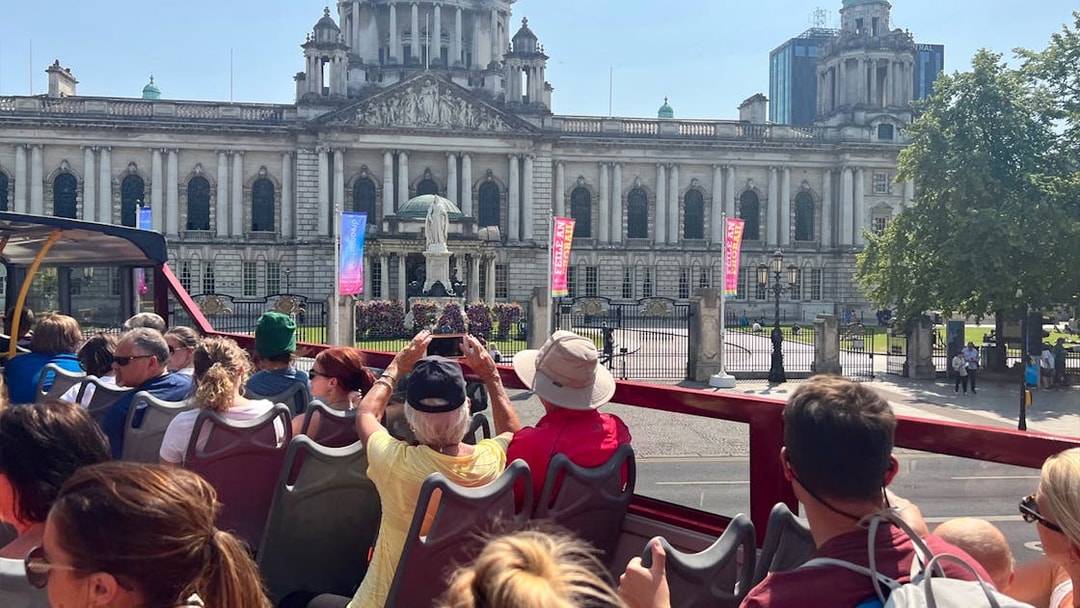 Open-top bus tour in front of Belfast City Hall.