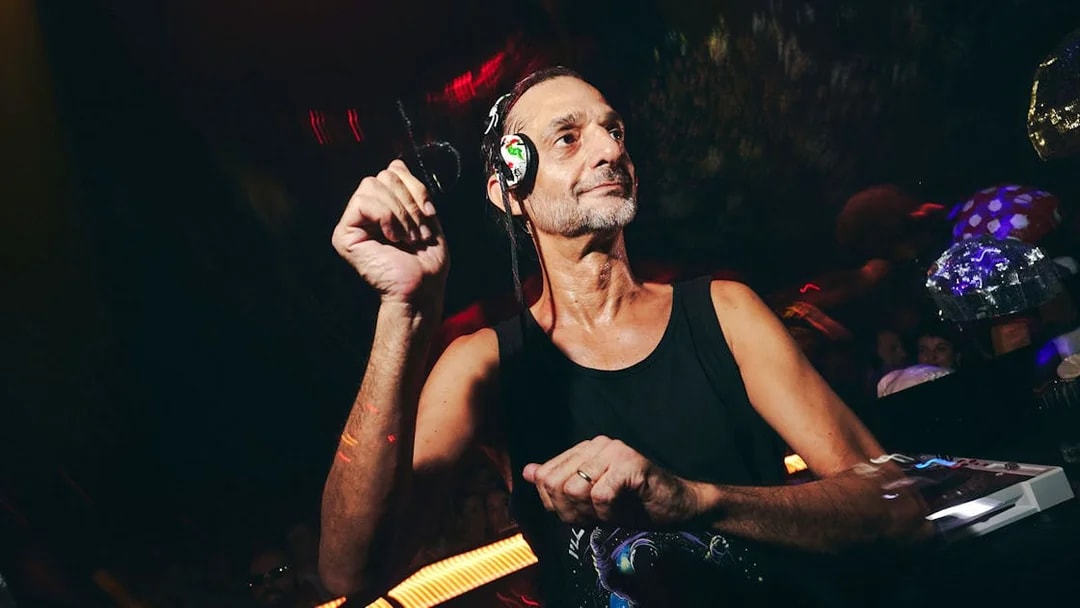 DJ performing at TRIP Club Chinois with vibrant lights and crowd in the background.
