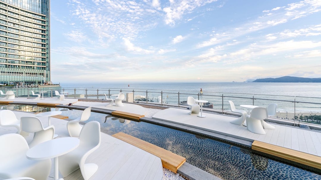 Outdoor terrace at Club D Oasis with modern seating and shallow water features by the sea.