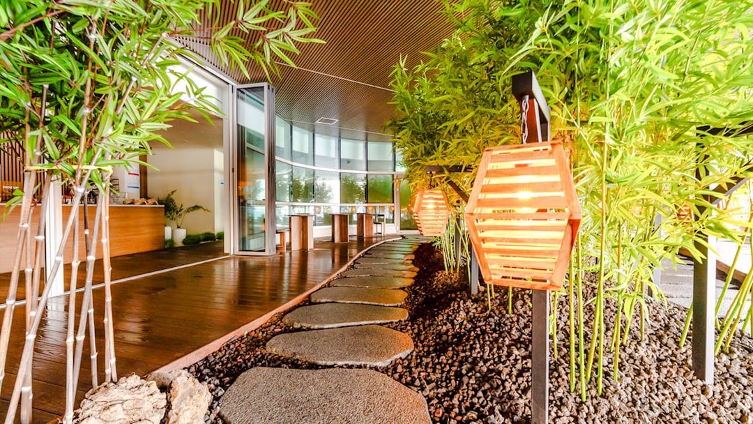 Stone pathway with glowing lanterns and bamboo decor in Club D Oasis spa area.