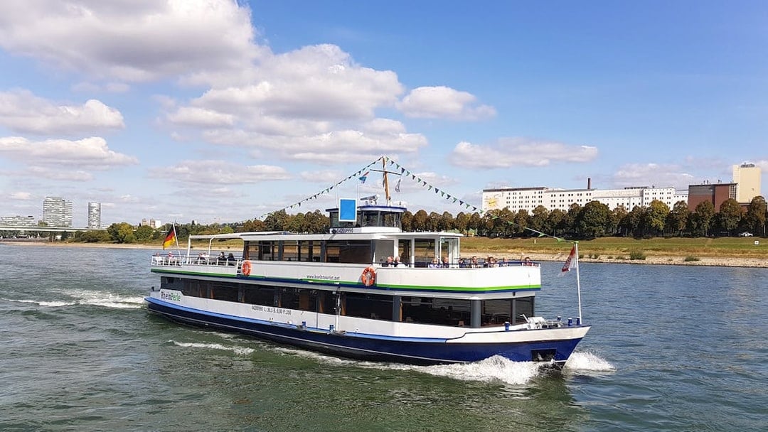 River cruise boat on the Rhine with Cologne skyline in the background.