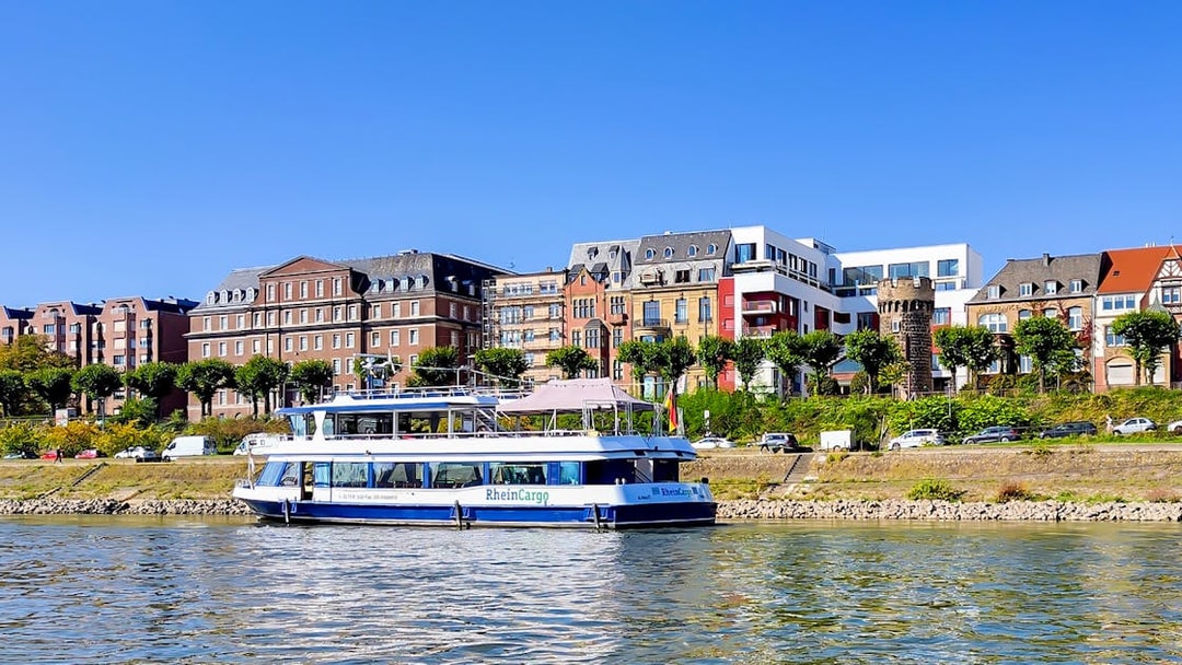 Cruise boat on the Rhine River with Cologne skyline in the background.