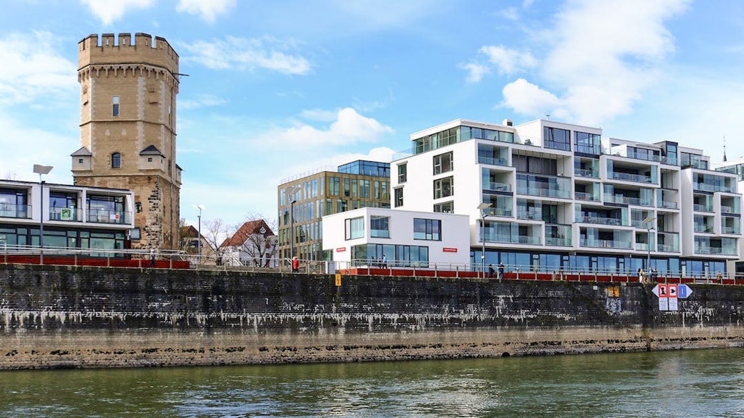 Cologne riverside with historic tower and modern buildings on skyline tour.