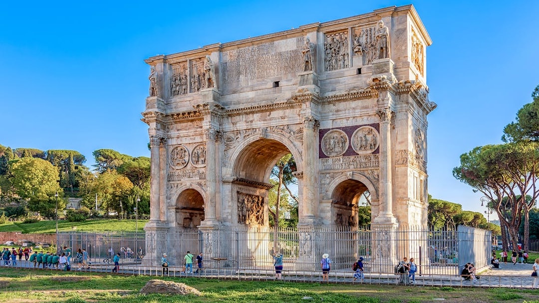 Arch of Constantine in Rome with tourists exploring the historic monument.