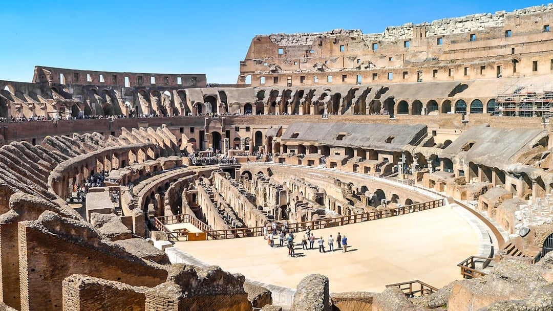 Visitors exploring the ancient Colosseum arena in Rome, Italy.