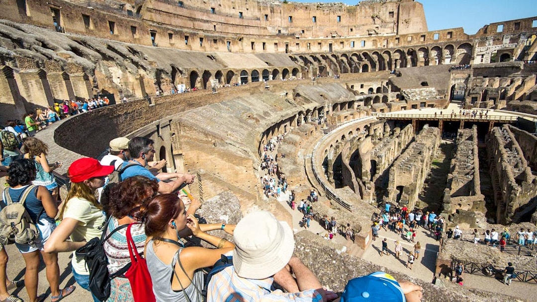 Tourists with a guide overlooking the interior of the Colosseum in Rome, Italy.