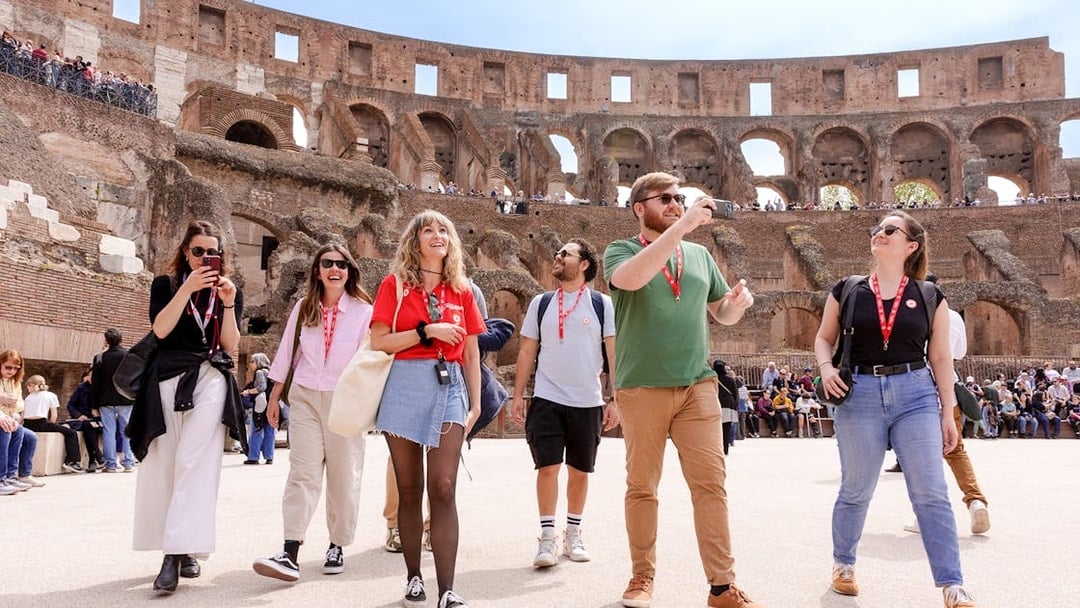 Visitors exploring the Colosseum arena during a guided tour in Rome.