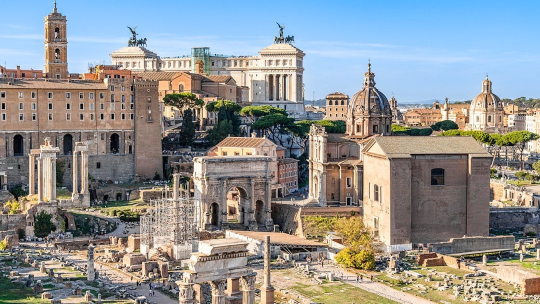 Roman Forum ruins with surrounding historic buildings, part of Colosseum, Palatine Hill & Roman Forum tour.