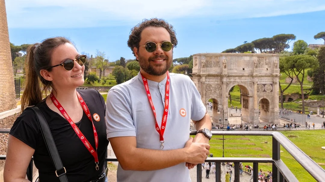 Tourists enjoying the view of the Arch of Constantine on a Colosseum, Palatine Hill & Roman Forum guided tour.