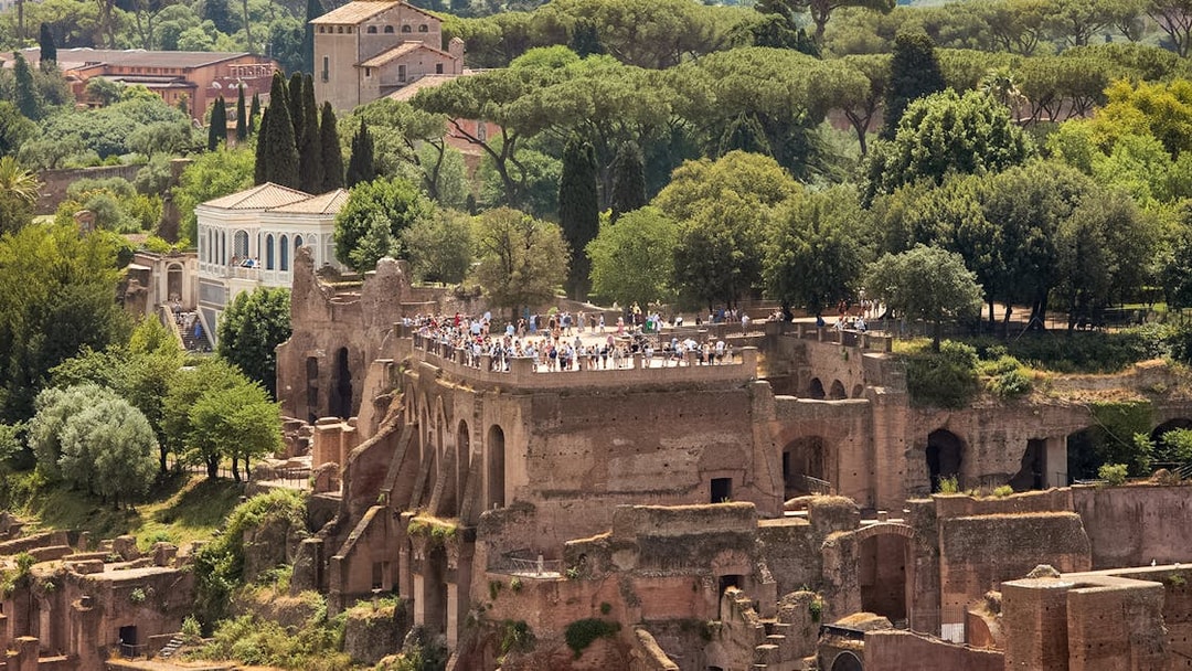 Tourists exploring Palatine Hill ruins in Rome, surrounded by lush greenery.