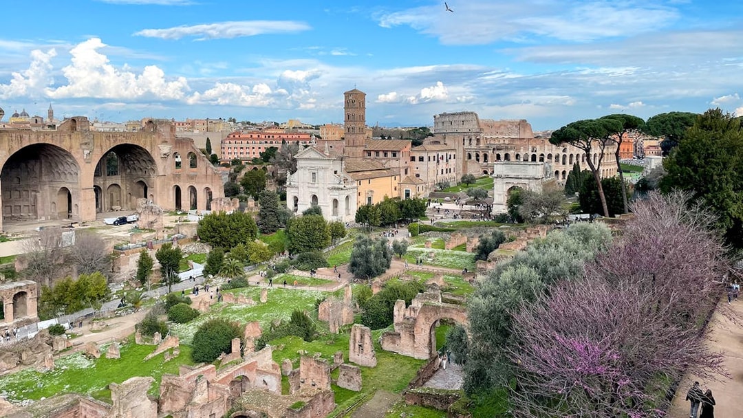 Ancient ruins of Palatine Hill and Roman Forum in Rome with surrounding greenery.