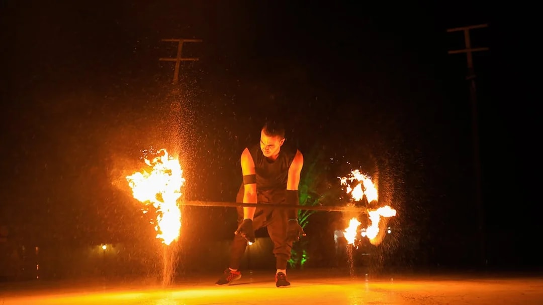 Fire performer spinning flames during Dubai desert safari.
