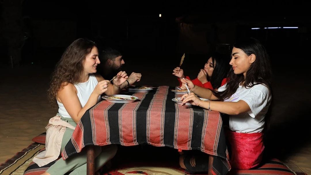 Guests dining at a Bedouin camp during a Dubai desert safari experience.