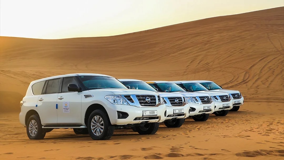 Four SUVs parked on Dubai desert sand during Red Dunes Desert Safari.