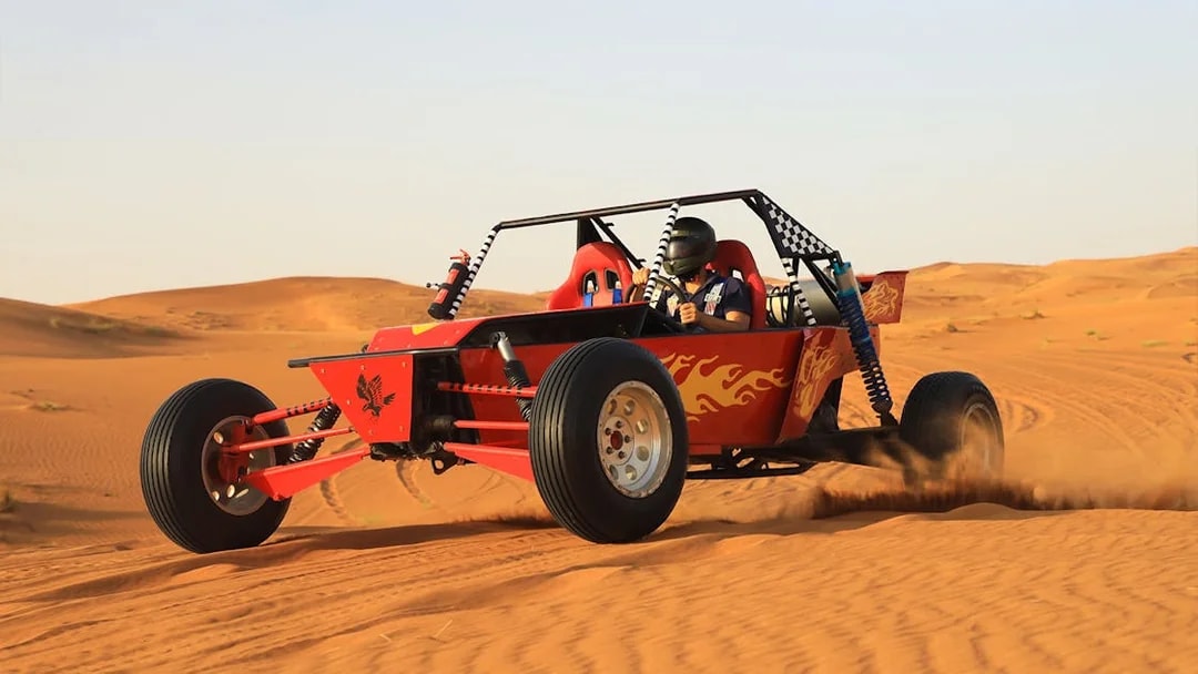 Dune buggy driving through Dubai's Red Dunes desert.