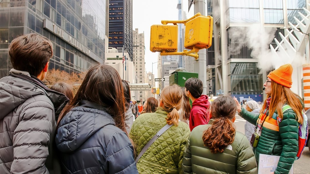 Group tour near One World Trade Center, New York City, listening to a guide.