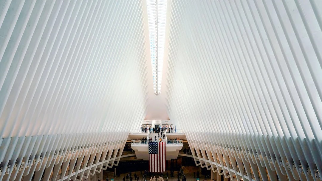 Interior view of The Oculus in New York City with people and American flag.