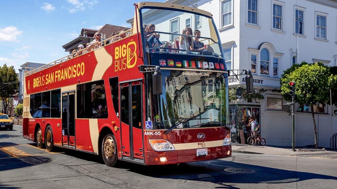 San Francisco hop-on hop-off tour bus driving through city streets.