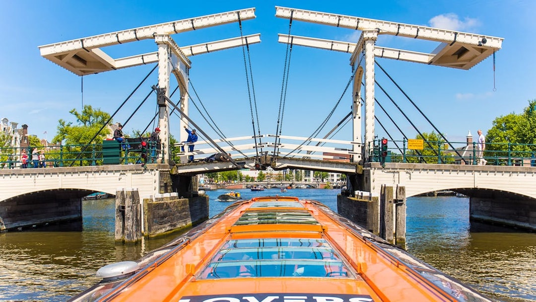 Amsterdam canal cruise boat approaching Magere Brug bridge.