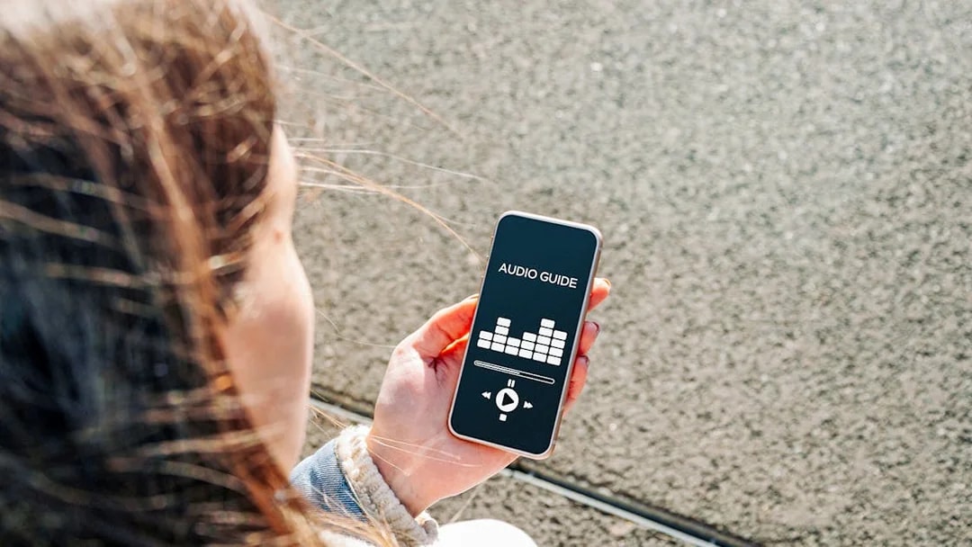 Person using an audio guide app on a smartphone at A'DAM Lookout.