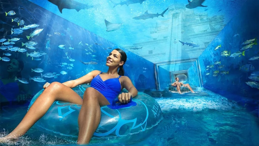 Visitors enjoying a water ride surrounded by marine life at Aquaventure, Atlantis Dubai.