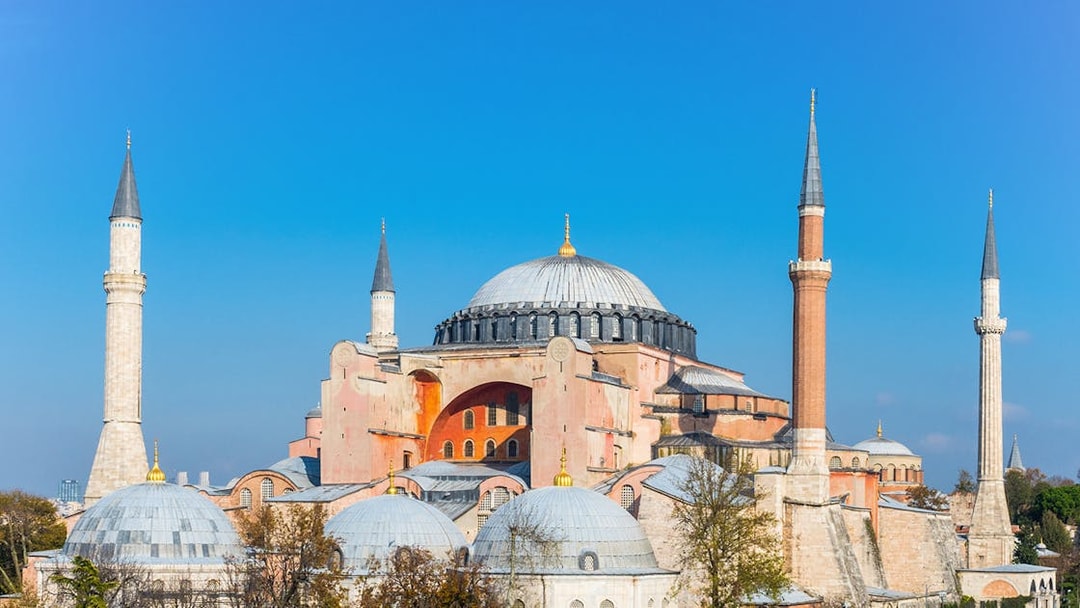 Hagia Sophia with minarets under clear blue sky in Istanbul.