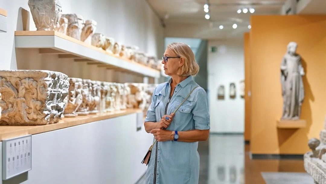 Visitor observing ancient artifacts at Athens National Archaeological Museum.