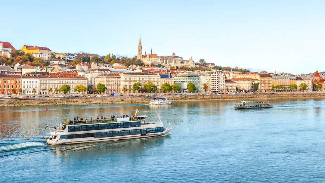 Budapest river cruise with cityscape view, including historic buildings and boats on the Danube.