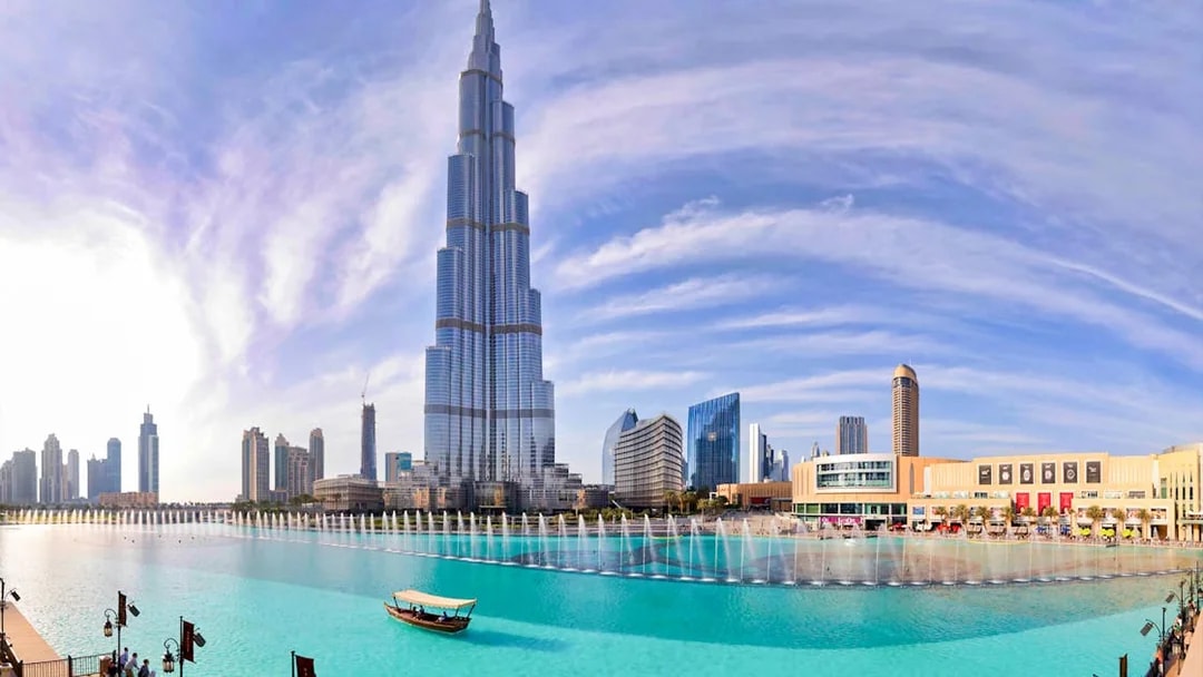 Burj Khalifa towering over Dubai Fountain with city skyline in the background.