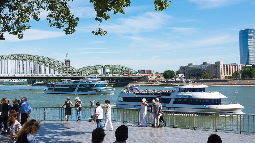 Cruise boats on the Rhine River with Hohenzollern Bridge in Cologne.
