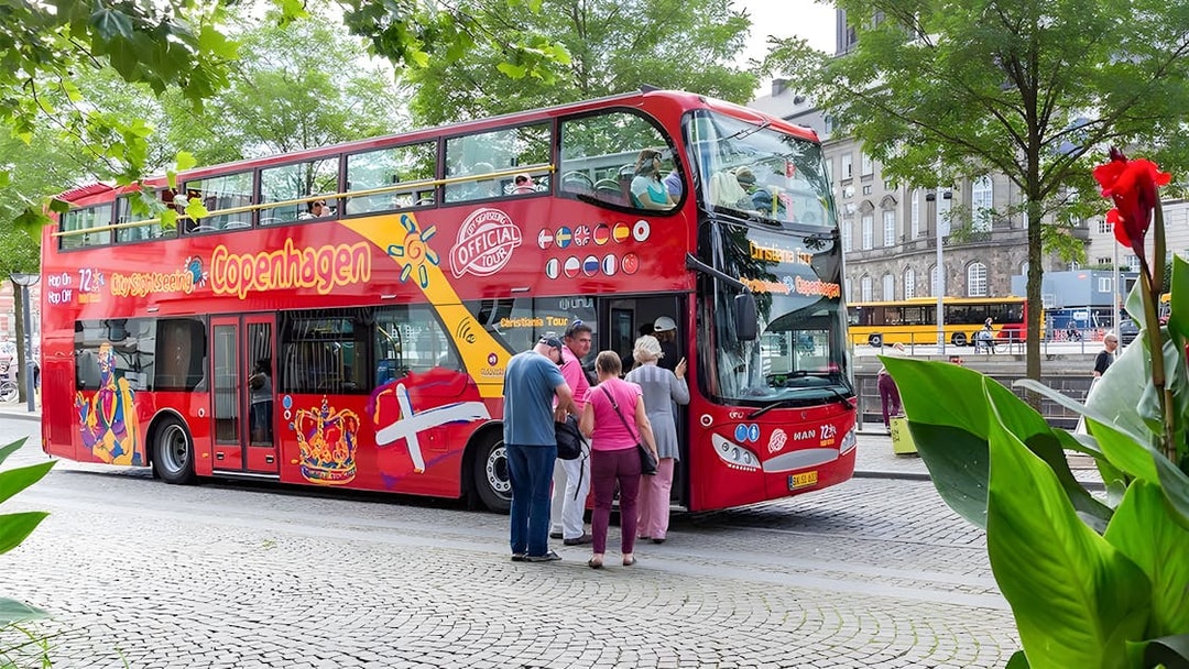 Tourists boarding a red hop-on hop-off bus in Copenhagen.