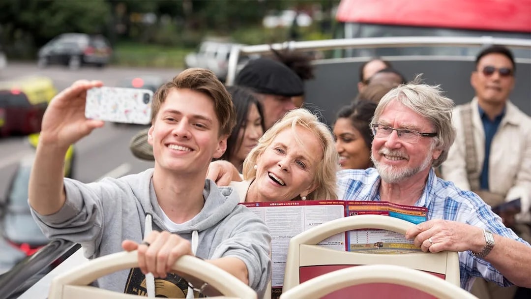 Family enjoying a ride on a HOHO Darwin tour bus, taking a selfie.