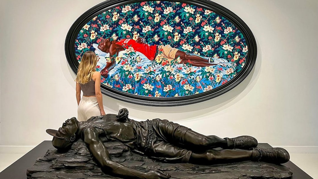 Visitor admiring art at Moco Museum, Barcelona, with a colorful painting and sculpture.