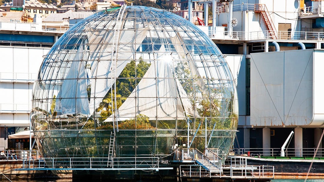 Genoa Aquarium Biosphere glass dome with plants inside, located by the waterfront.