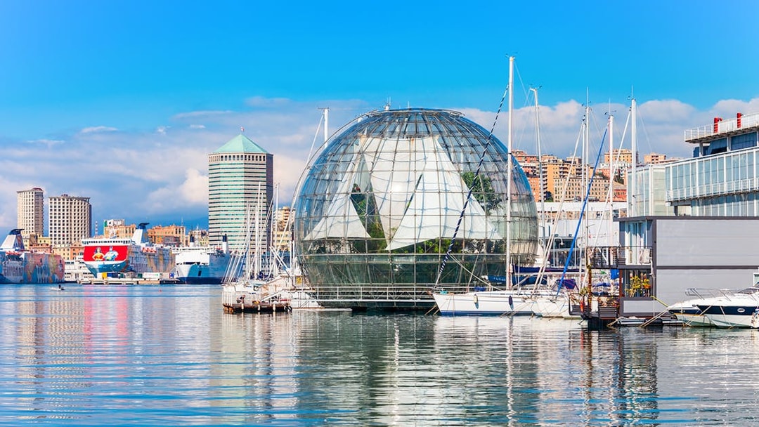 Genoa harbor with Biosphere near Aquarium of Genoa, boats and cityscape in background.