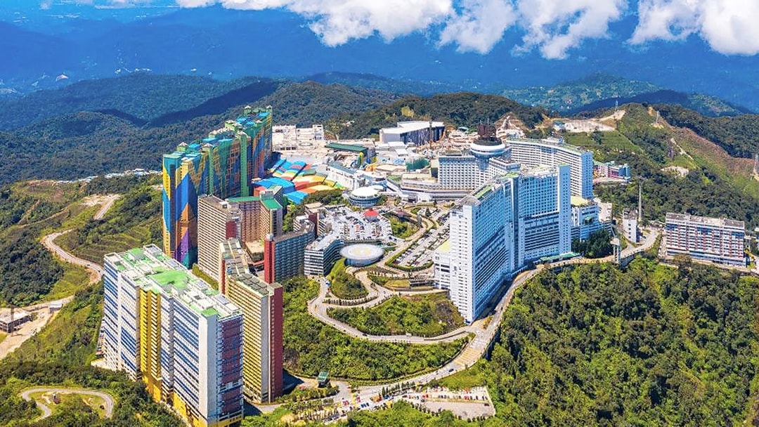 Aerial view of Genting Highlands resort complex surrounded by lush green hills.