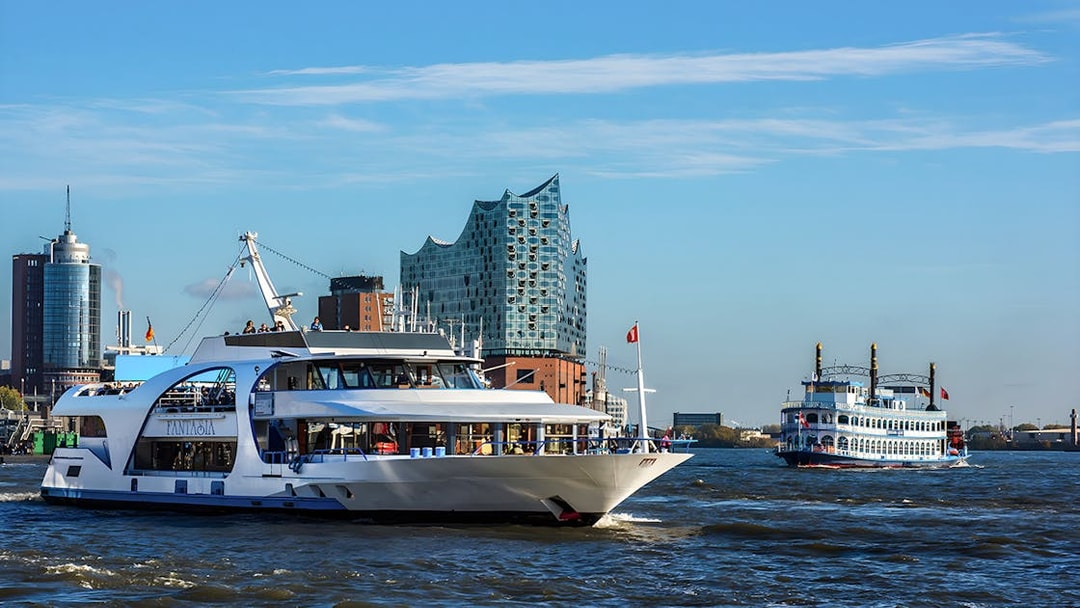 Cruise boats on the Elbe River with Elbphilharmonie in Hamburg.