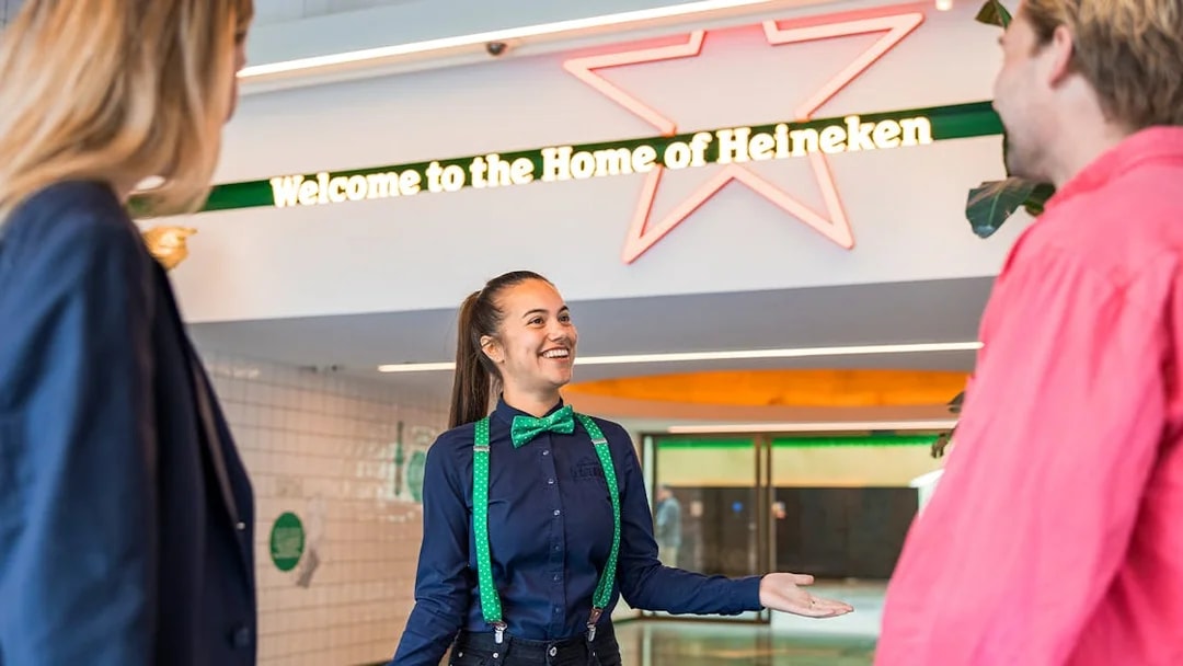 Tourists with guide at Heineken Experience entrance in Amsterdam.