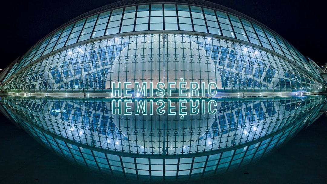 Hemisfèric building illuminated at night, Valencia, Spain.