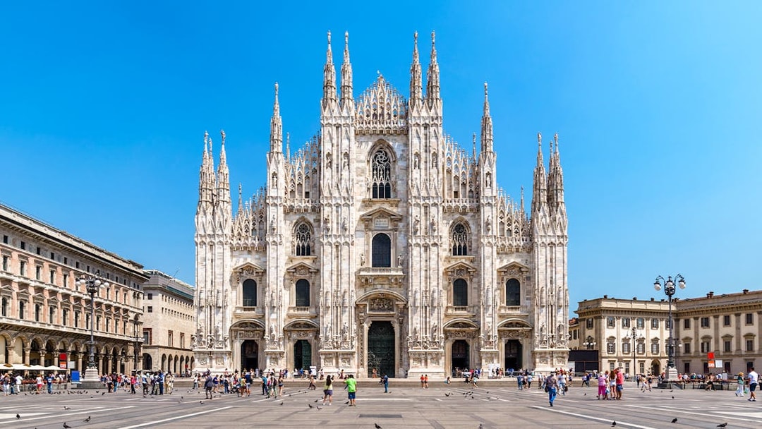 Milan Cathedral facade with tourists in Piazza del Duomo, Italy.