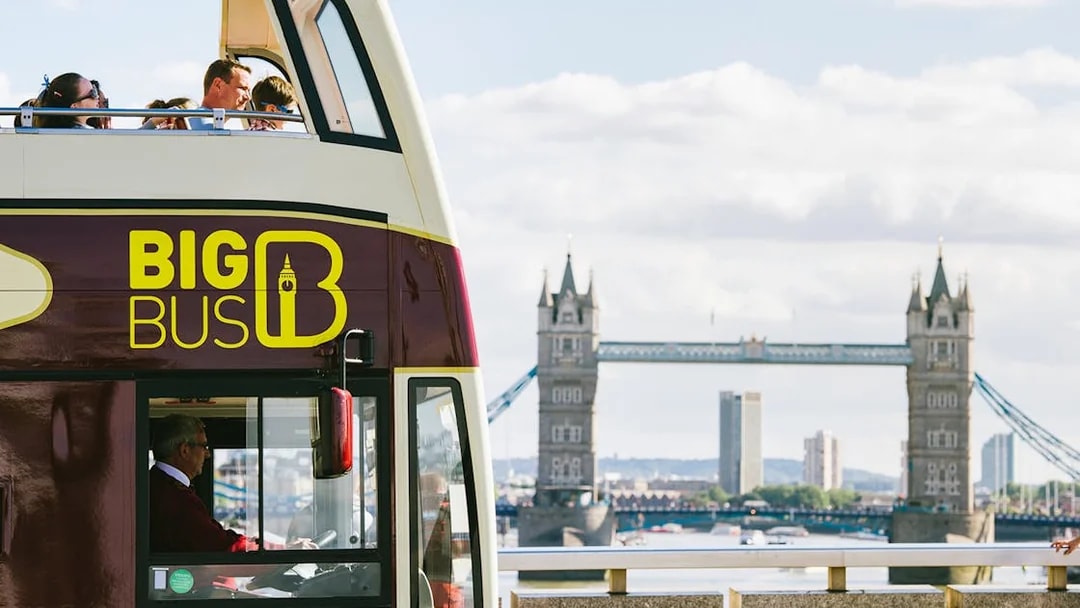 Big Bus tour near Tower Bridge with Thames River view in London.