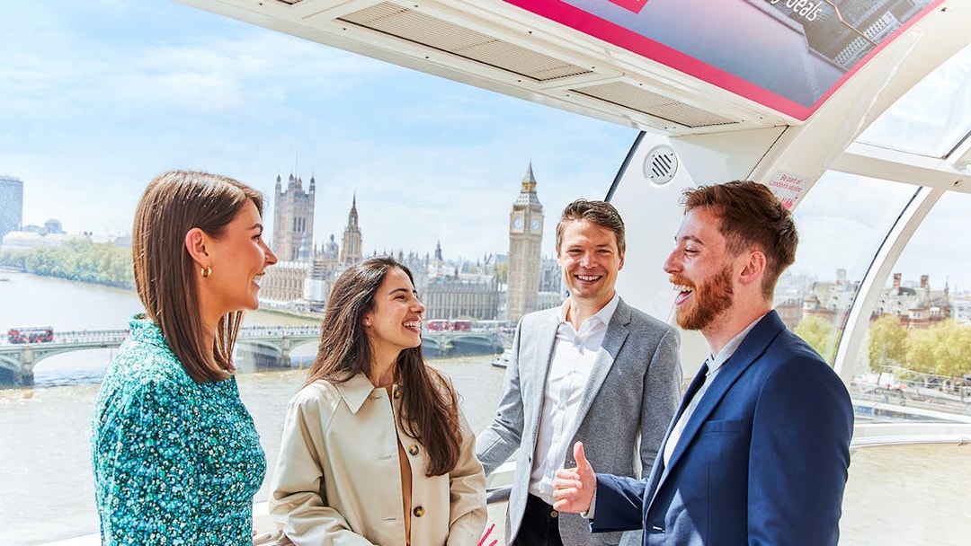 Group enjoying view of Big Ben and Houses of Parliament from London Eye capsule.