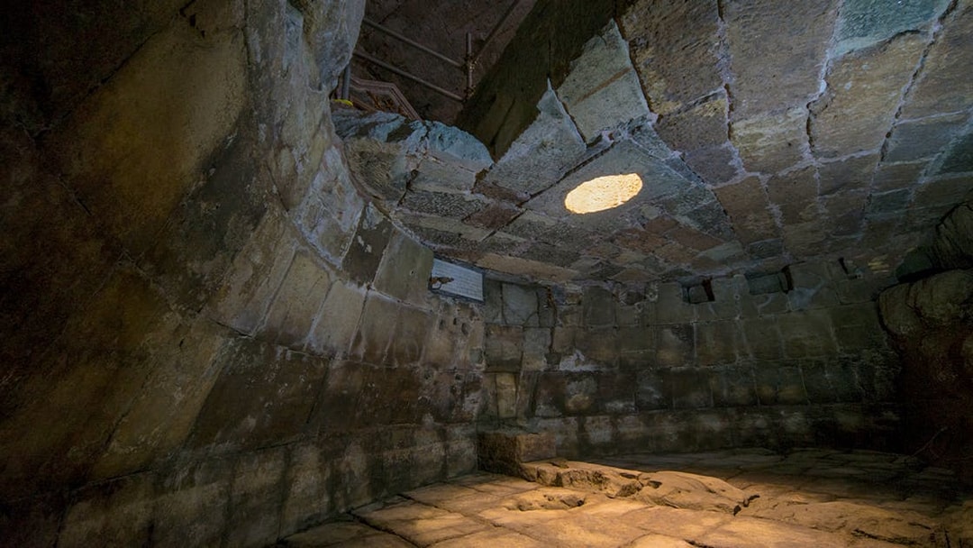 Ancient stone chamber with a circular opening in the ceiling, Lupercale, Rome.