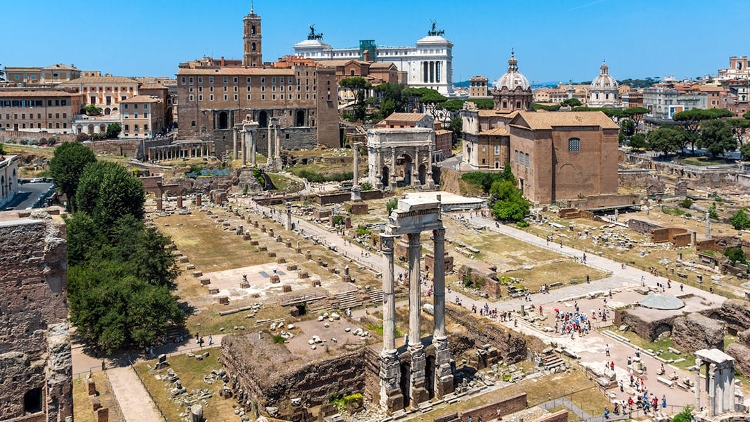 Palatine Hill view of Roman Forum ruins in Rome, Italy, with ancient columns and historic buildings.