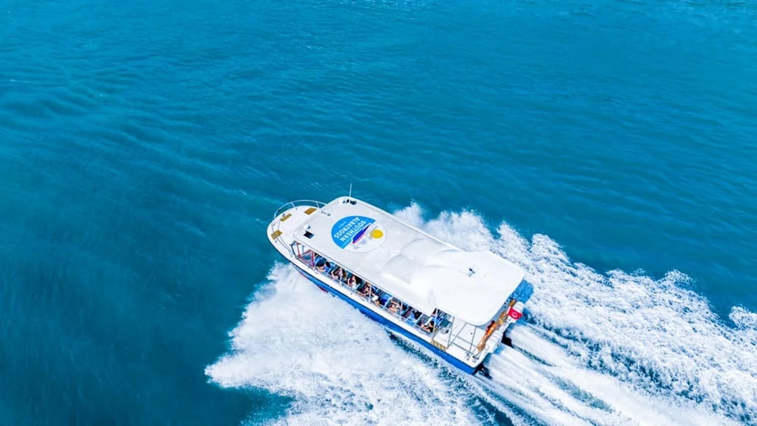 Tour boat cruising on blue waters, part of Combo Mega Adventure in Singapore.